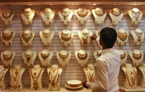 A salesman arranges a gold necklace inside a gold jewellery showroom in the southern Indian city of Kochi April 16, 2012. Indian gold futures are likely to extend losses this week, falling below a one-week low touched on Monday, hurt by a firm dollar overseas, although a revival in physical demand ahead of key festival could limit the downside, analysts said. REUTERS/Sivaram V (INDIA - Tags: BUSINESS COMMODITIES) - RTR30T4Q